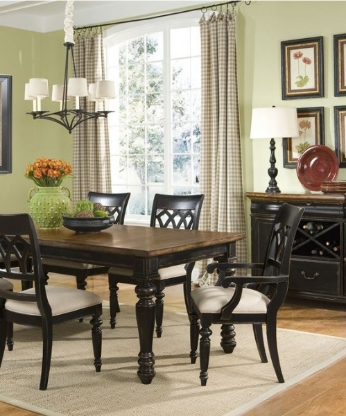 Деревянная вычурная мебель черного цвета гармонирует со спокойным цветом стен столовой.